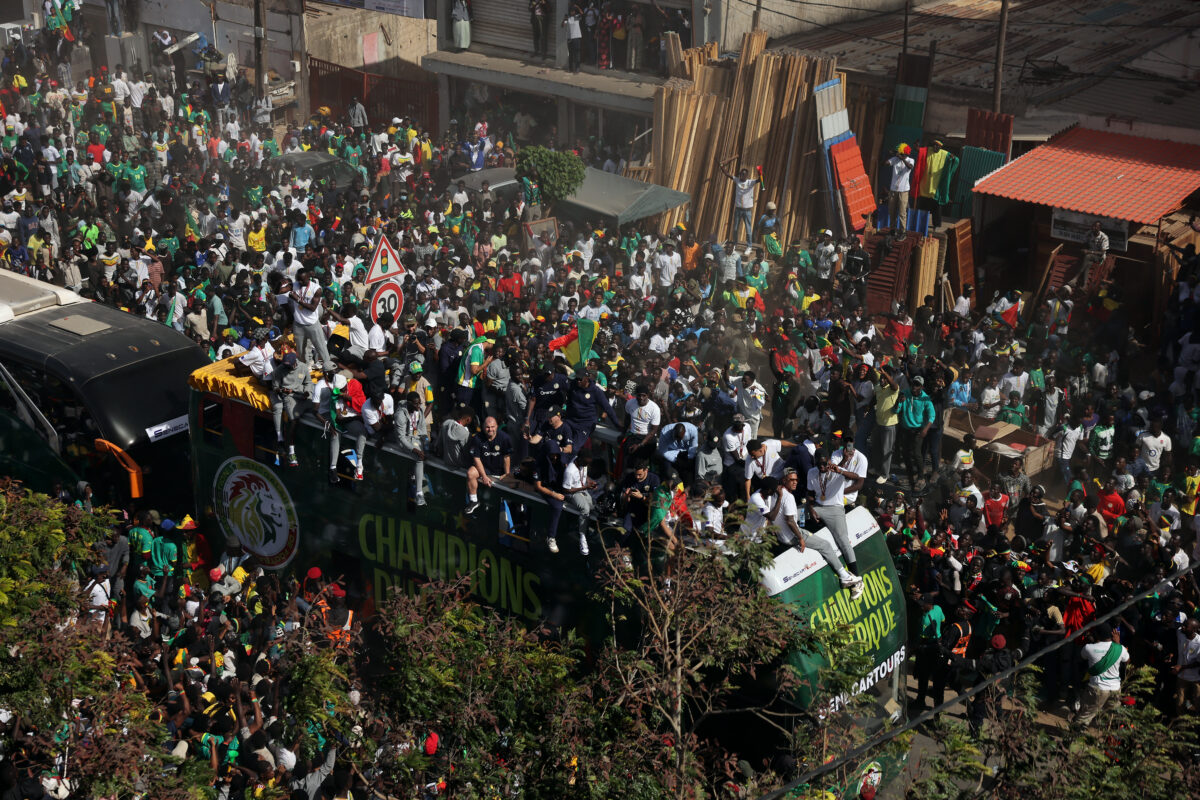 Soccer Football - CAF Africa Cup of Nations - Morocco 2025 - Final - Senegal Victory Parade - Dakar, Senegal - January 20, 2026 Senegal players and staff with the trophy on the bus as fans celebrate during the parade REUTERS
