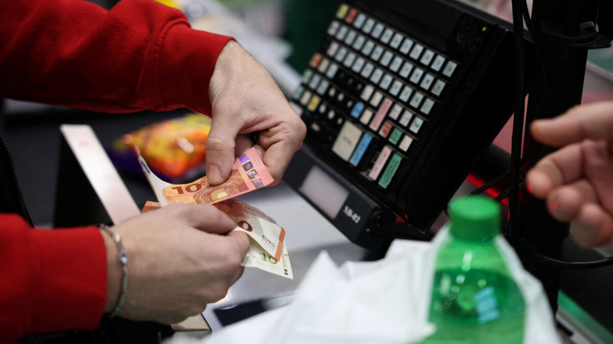 A person holds change in euros as customers shop in Fantastico store, on the day of the country’s accession to the Eurozone, in Sofia