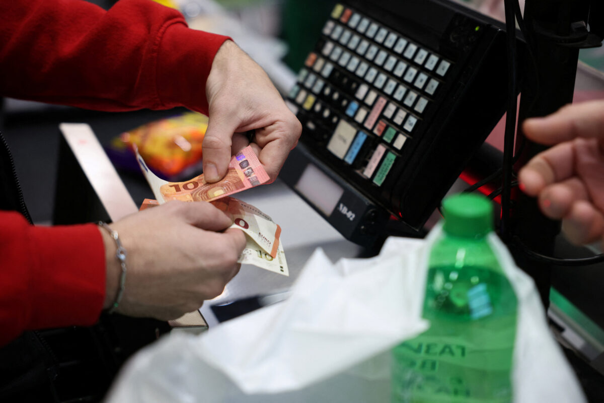 A person holds change in euros as customers shop in Fantastico store, on the day of the country’s accession to the Eurozone, in Sofia
