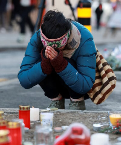 Άνθρωποι αποτίουν φόρο τιμής δίπλα στα κεριά που έχουν τοποθετηθεί για τα θύματα έξω από το μπαρ «Le Constellation», μετά από πυρκαγιά και έκρηξη κατά τη διάρκεια πάρτι της Πρωτοχρονιάς, όπου αρκετοί άνθρωποι έχασαν τη ζωή τους και άλλοι τραυματίστηκαν, σύμφωνα με την ελβετική αστυνομία, στο πολυτελές χιονοδρομικό κέντρο Crans-Montana στη νοτιοδυτική Ελβετία