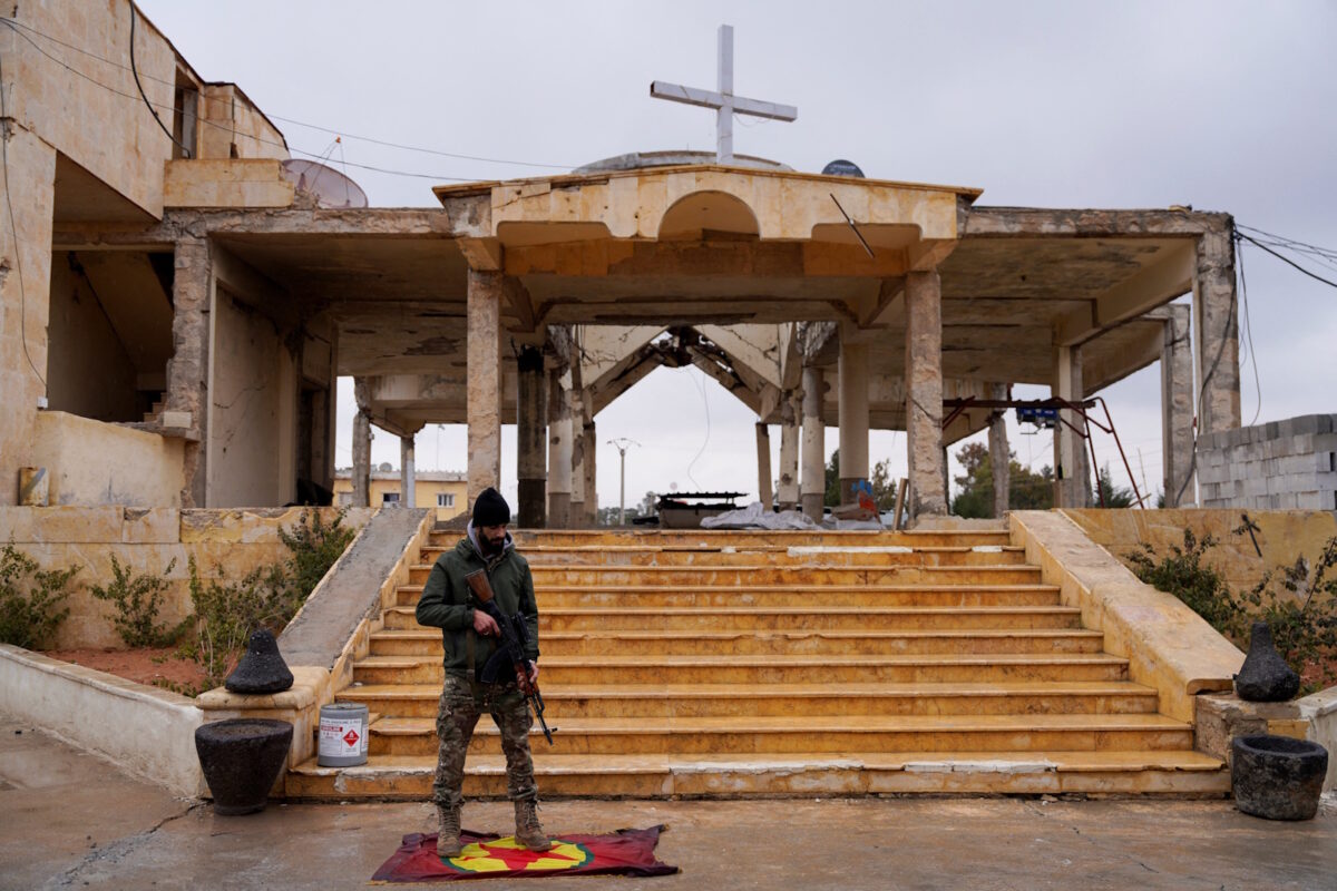 Μέλος του συριακού στρατού πατάει την σημαία των Κούρδων μαχητών