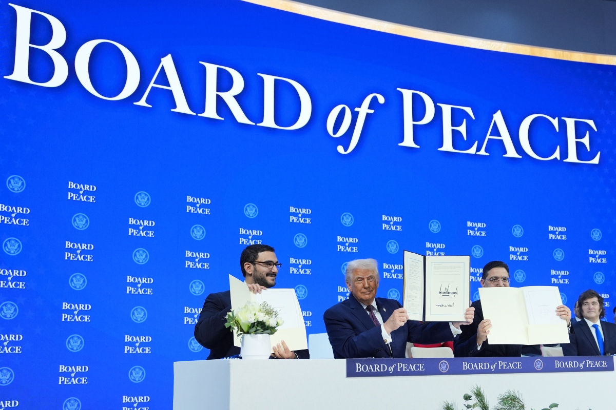 President Donald Trump, center, holds up a signed Board of Peace charter during the Annual Meeting of the World Economic Forum in Davos, Switzerland, Thursday, Jan. 22, 2026.
