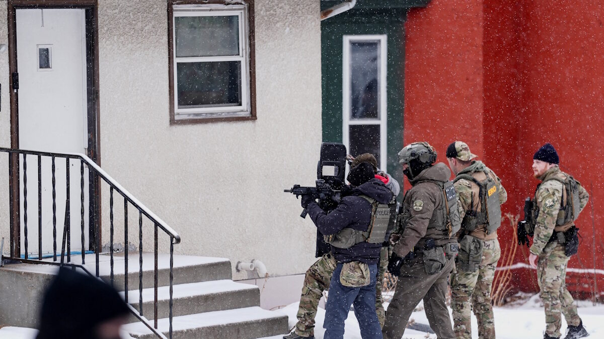 Ένας αστυνομικός σημαδεύει με όπλο ένα σπίτι κατά τη διάρκεια επιδρομής της υπηρεσίας μετανάστευσης στο Σεντ Πολ της Μινεσότα