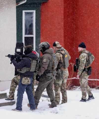 Ένας αστυνομικός σημαδεύει με όπλο ένα σπίτι κατά τη διάρκεια επιδρομής της υπηρεσίας μετανάστευσης στο Σεντ Πολ της Μινεσότα