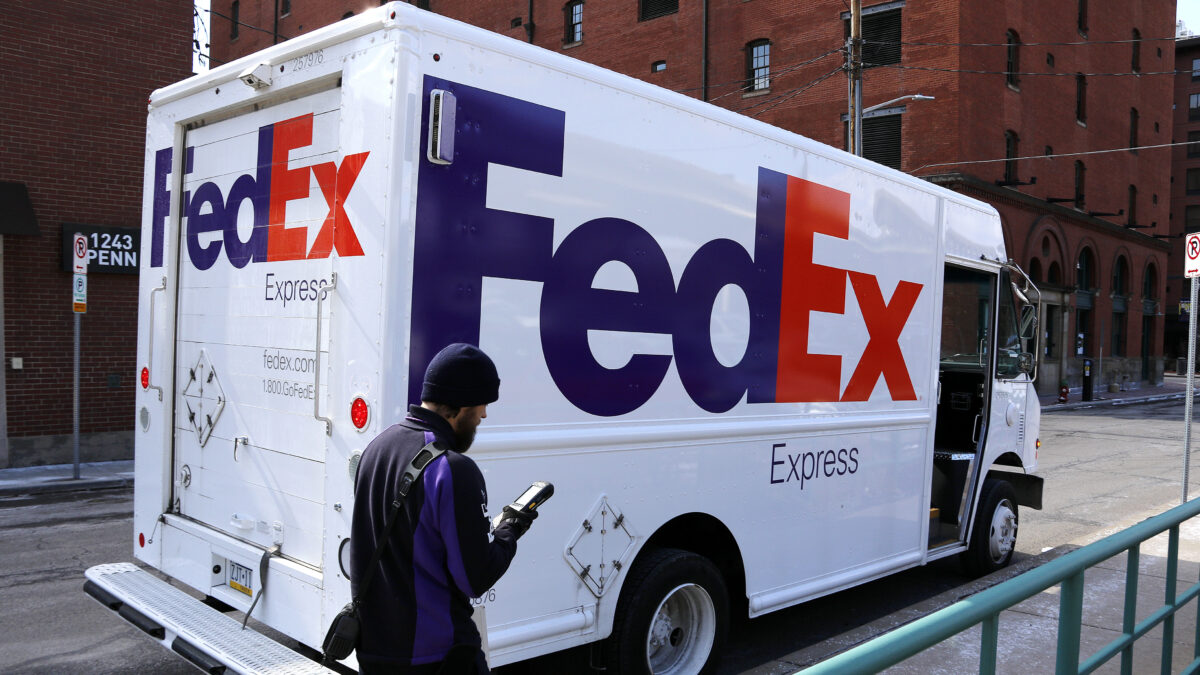 In this Friday, March 17, 2017, photo, a FedEx driver returns to his truck in downtown Pittsburgh. FedEx Corp. reports earnings Tuesday, Dec. 19, 2017. (AP Photo/Gene J. Puskar)