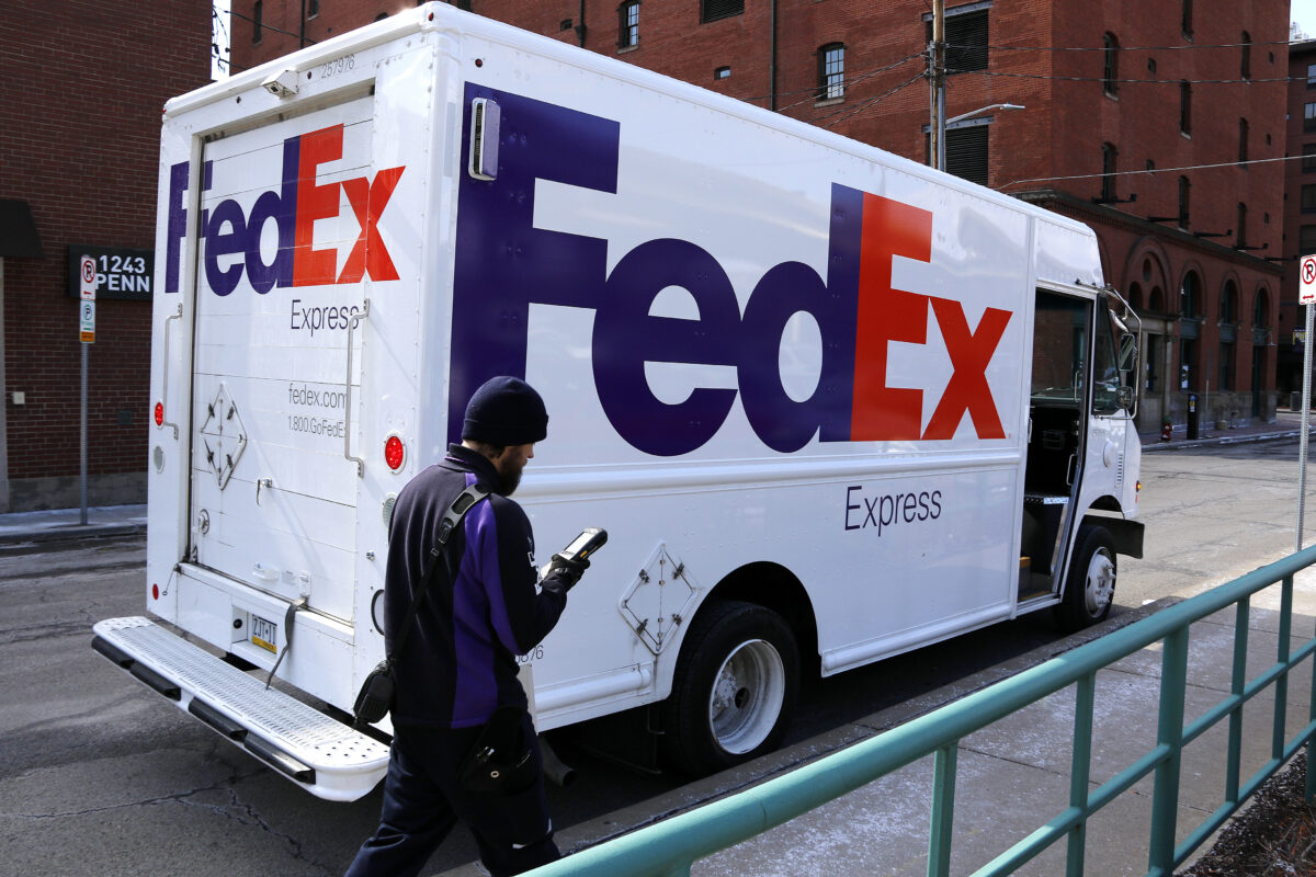 In this Friday, March 17, 2017, photo, a FedEx driver returns to his truck in downtown Pittsburgh. FedEx Corp. reports earnings Tuesday, Dec. 19, 2017. (AP Photo/Gene J. Puskar)