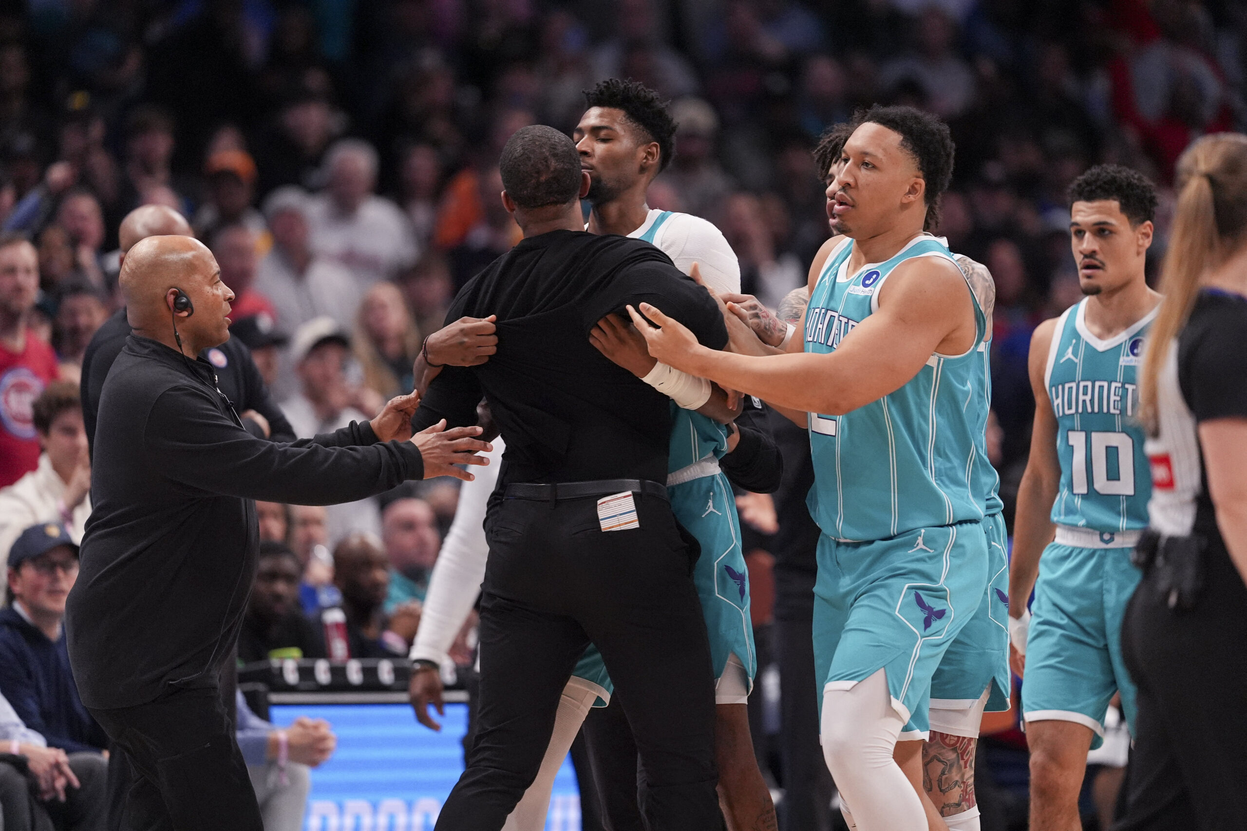 Feb 9, 2026; Charlotte, North Carolina, USA; Charlotte Hornets forward Brandon Miller (24) and forward Grant Williams (2) hold back Head Coach Charles Lee after his ejection during the second half against the Detroit Pistons at Spectrum Center. Mandatory Credit: Jim Dedmon-Imagn Images