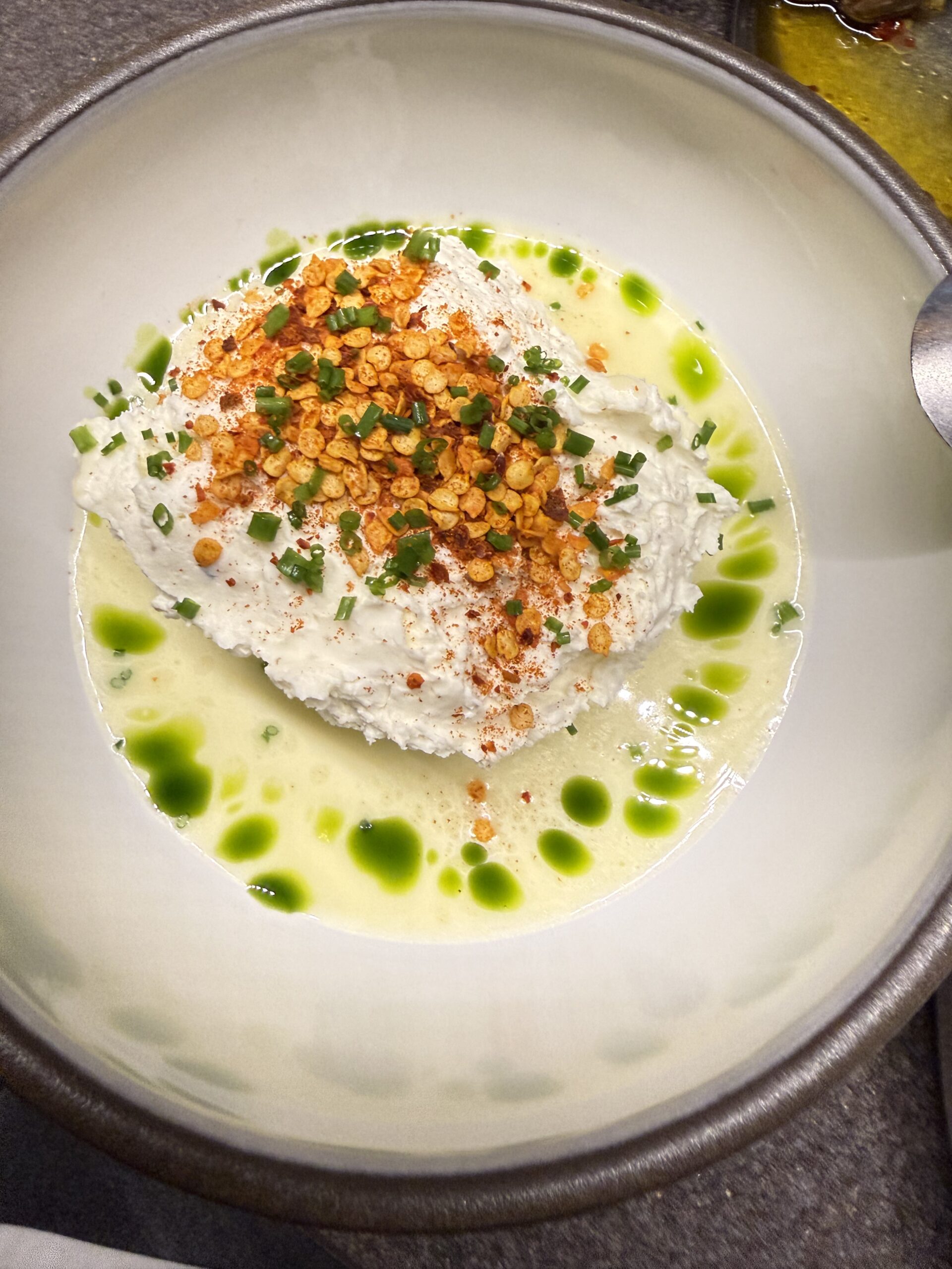 Η τυροκαυτερή με φέτα, γκερεμέζι και ανθότυρο, πάνω σε κρέμα από πράσινα τσίλι Κρήτης.