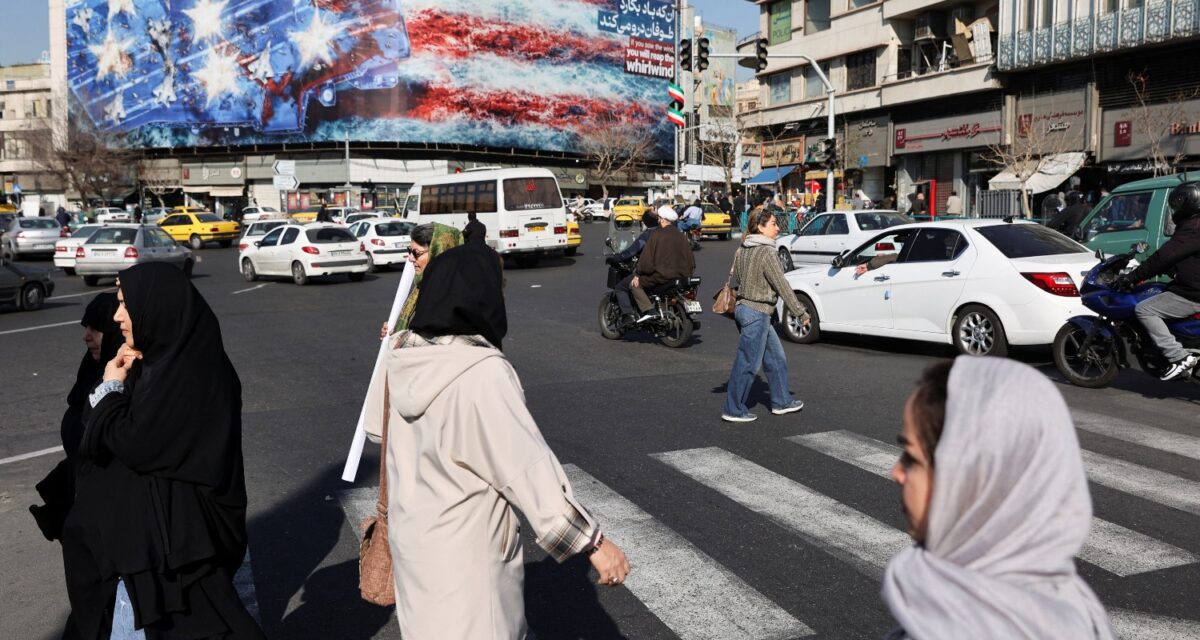 People walk past an anti-U.S. billboard on a street in Tehran, Iran, February 17, 2026. Majid Asgaripour/WANA (West Asia News Agency) / REUTERS