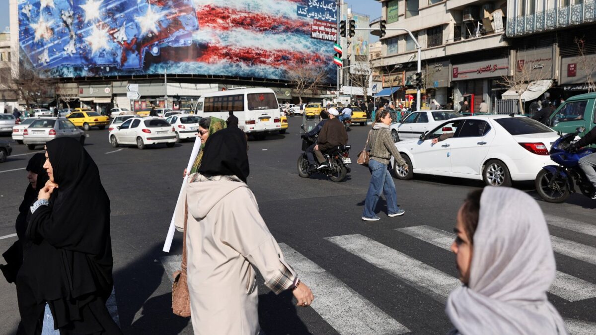 People walk past an anti-U.S. billboard on a street in Tehran, Iran, February 17, 2026. Majid Asgaripour/WANA (West Asia News Agency) / REUTERS
