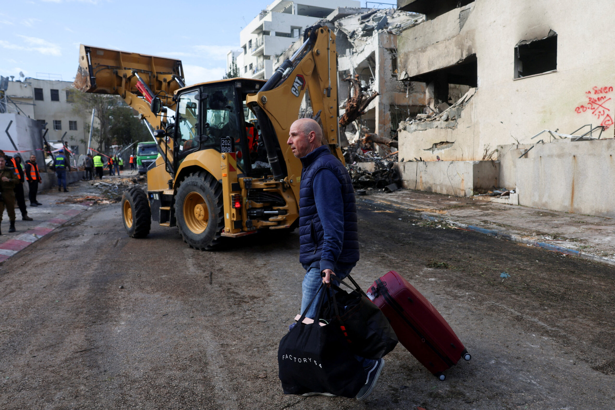 Aftemath of Iranian missile strike, after Israel and the U.S. launched strikes on Iran A man carries luggage at the site of an Iranian missile strike on a residential building, after Iran launched missile barrages following attacks by the U.S. and Israel on Saturday, in Tel Aviv, Israel March 1, 2026. REUTERS/Ronen Zvulun TPX IMAGES OF THE DAY
