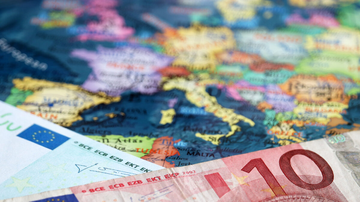 Euro banknotes on the map of Europe, selective focus. Concept for european economy, eurozone countries
