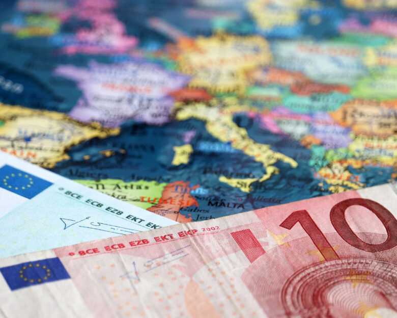 Euro banknotes on the map of Europe, selective focus. Concept for european economy, eurozone countries