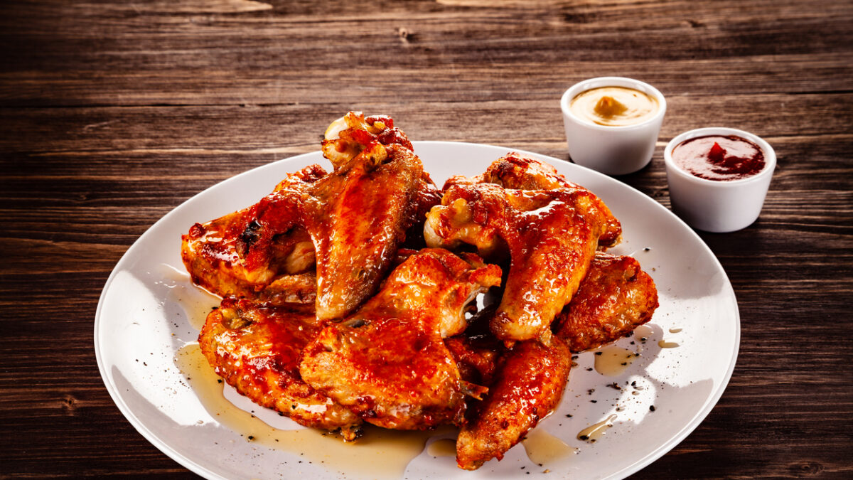 Chicken wings and vegetables on wooden table