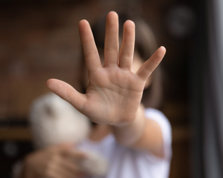 Crop close up of little girl child stretch hand show no gesture protest against domestic violence. Small teen child stand against discrimination or school abuse. Childhood problem, voice concept.
