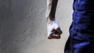 man closing his hand tightly. Clenched fist. Hand gesture. Fight, strength and determination concept.