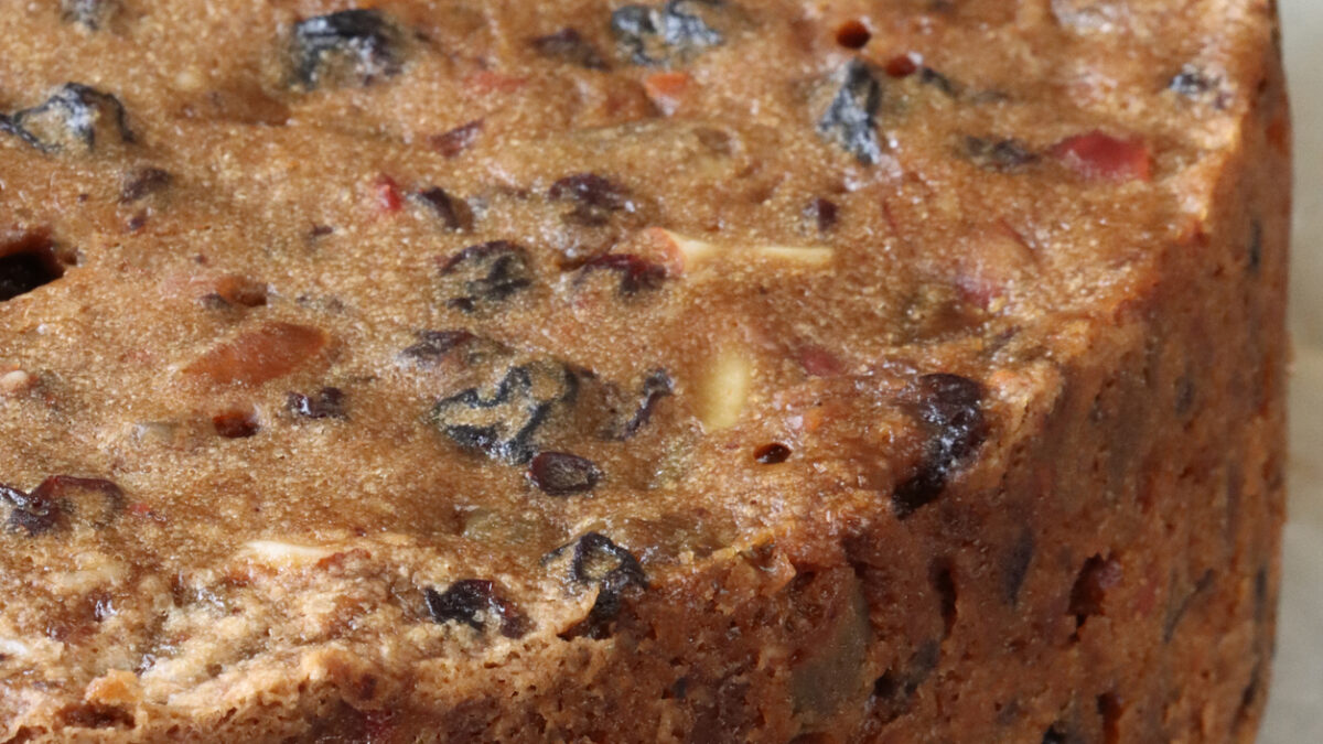 Stock photo showing a close-up view of a homemade Christmas fruitcake with nuts, sultanas and other dried fruit.
