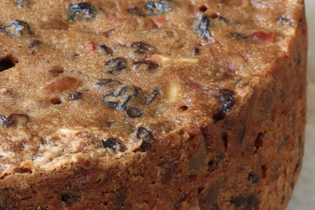 Stock photo showing a close-up view of a homemade Christmas fruitcake with nuts, sultanas and other dried fruit.