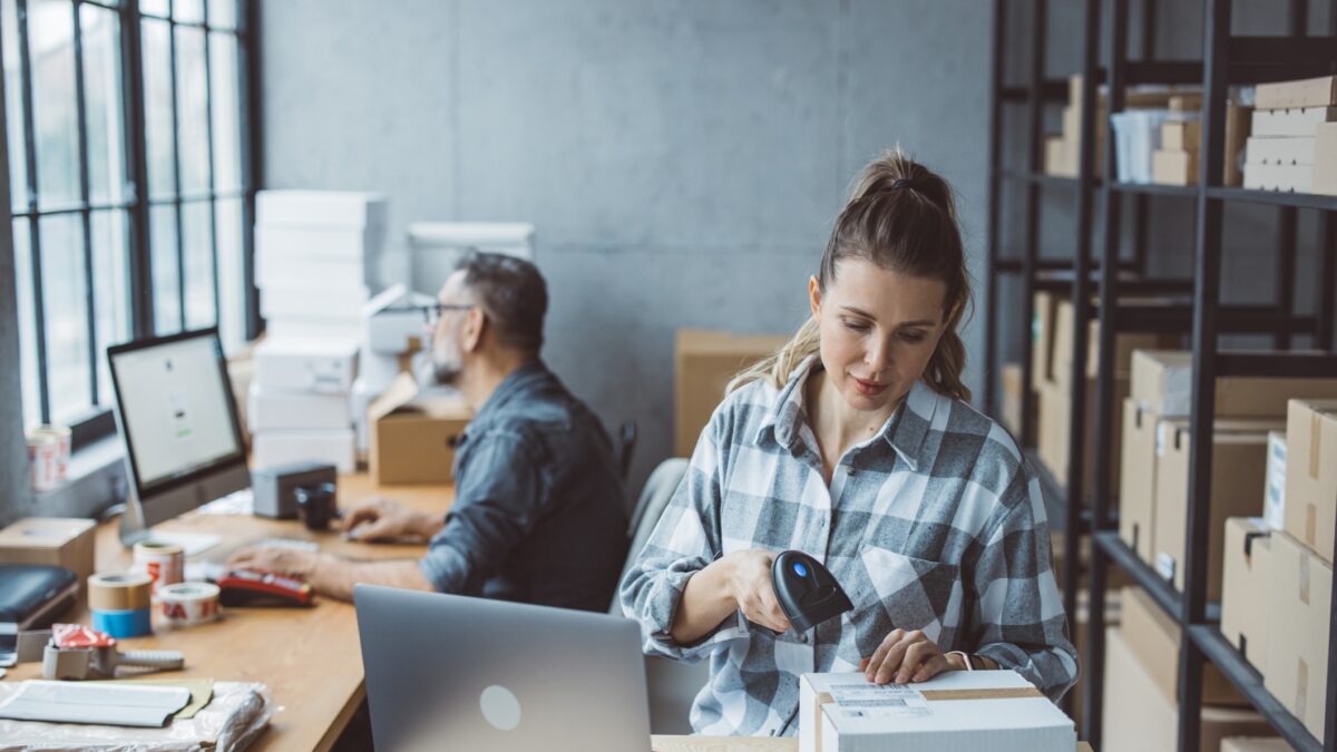 Two business partners working together at warehouse for online seller business.