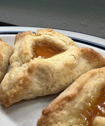 Close-up of apricot hamantaschen cookies for the Jewish holiday of Purim on a white plate, Lafayette, California, March 10, 2022. Photo courtesy Sftm