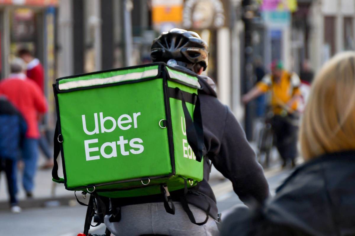 Cardiff, Wales - March 2022: Cycle courier for the Uber Eats food delivery service riding through the city centre
