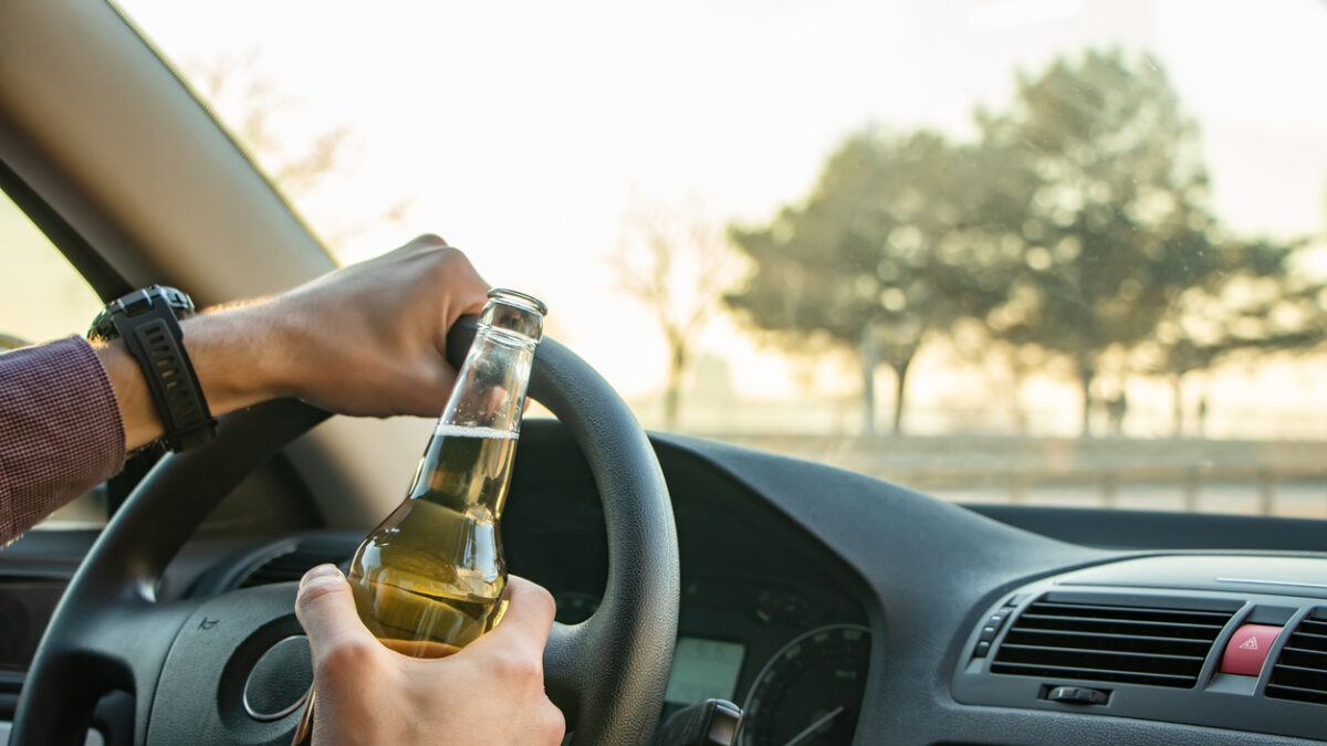 Man drinking alcohol while driving in his car.