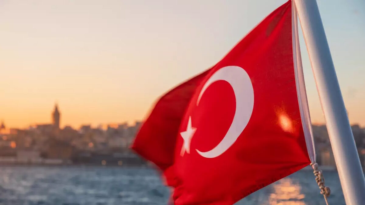 Waving Turkish flag on a ferry boat against Bosporus or Strait of Istanbul at sunset