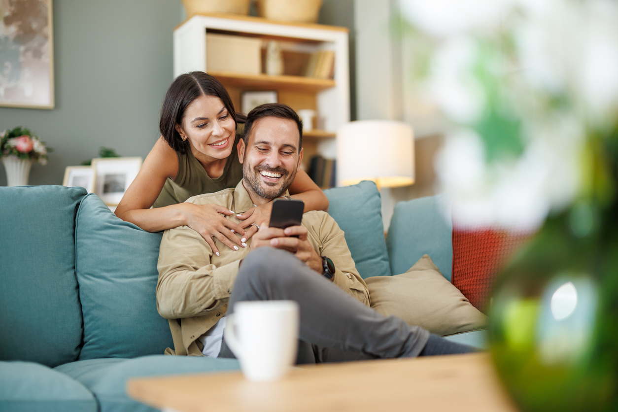 Young couple at home drinking coffee in their new home. Enjoying in weekend.