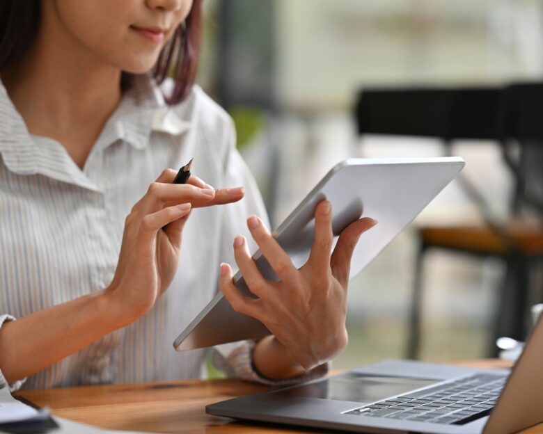 Close up or cropped image of Business and financial woman using tablet and laptop for working.