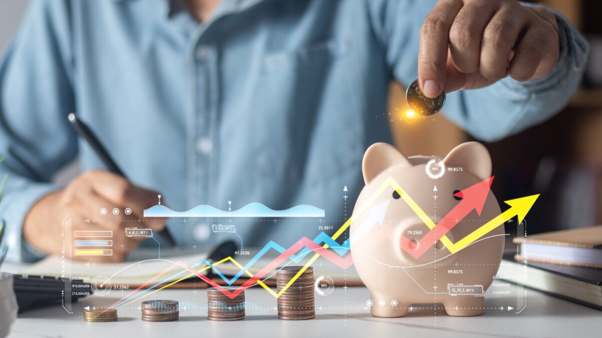 Man putting coins in piggy bank and taking notes in notebook money saving concept business