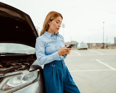 Stressed business woman calling roadside assistance after her car broke down. Accident and breakdowns with auto concept.