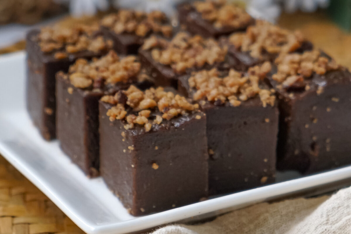 Kuih kole kacang, a steamed Malaysian cake, made with fried green bean flour, coconut milk, and palm sugar. The decoration of the cake is from coconut oil grease or residue. Selective focus.