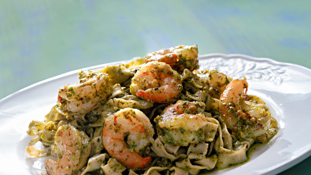 close up of a plate of seafood pasta in pesto sauce