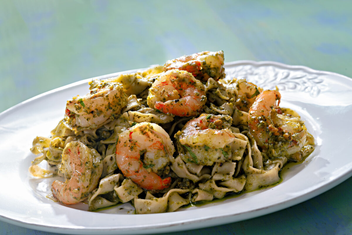 close up of a plate of seafood pasta in pesto sauce