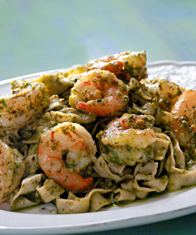 close up of a plate of seafood pasta in pesto sauce
