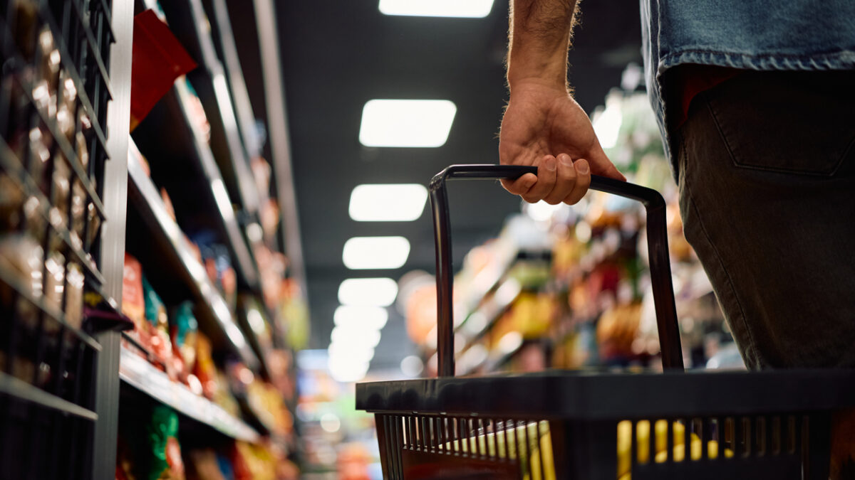 Close up of man buying groceries in supermarket. Copy space.