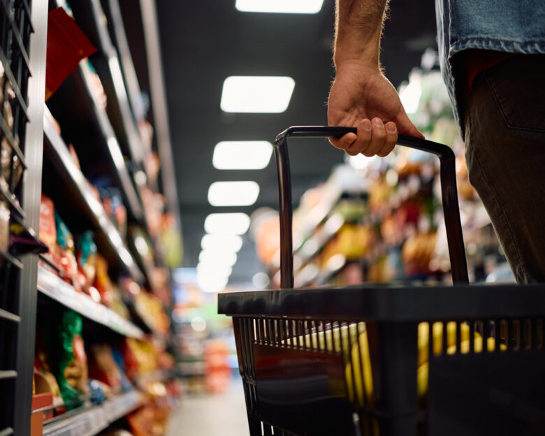 Close up of man buying groceries in supermarket. Copy space.