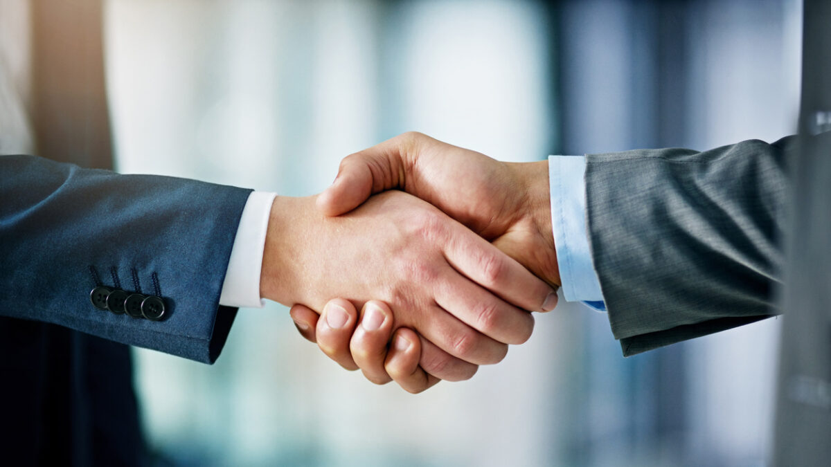 Closeup shot of two businessmen shaking hands in an office