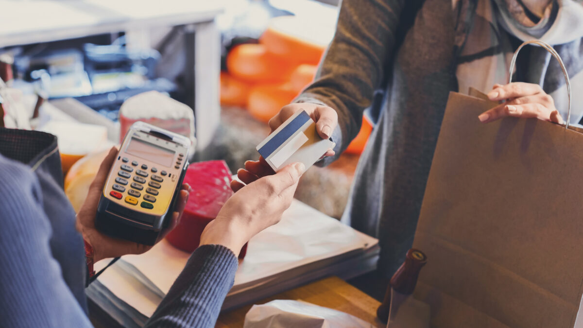 Retail, credit card payment service. Customer paying for order of cheese in grocery shop.