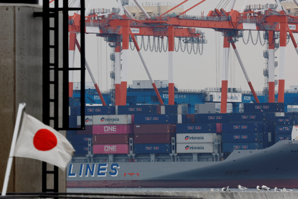 Η ιαπωνική εθνική σημαία κυματίζει μπροστά από εμπορευματοκιβώτια