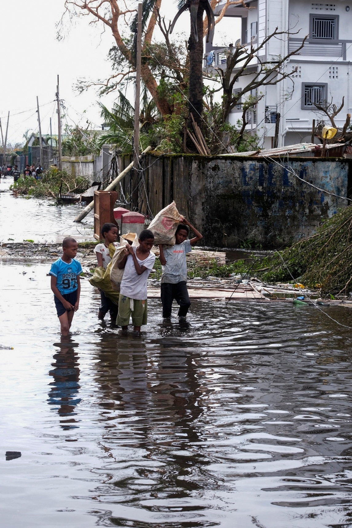 Κάτοικοι της Μαδαγασκάρης περπατούν σε πλημμυρισμένο δρόμο