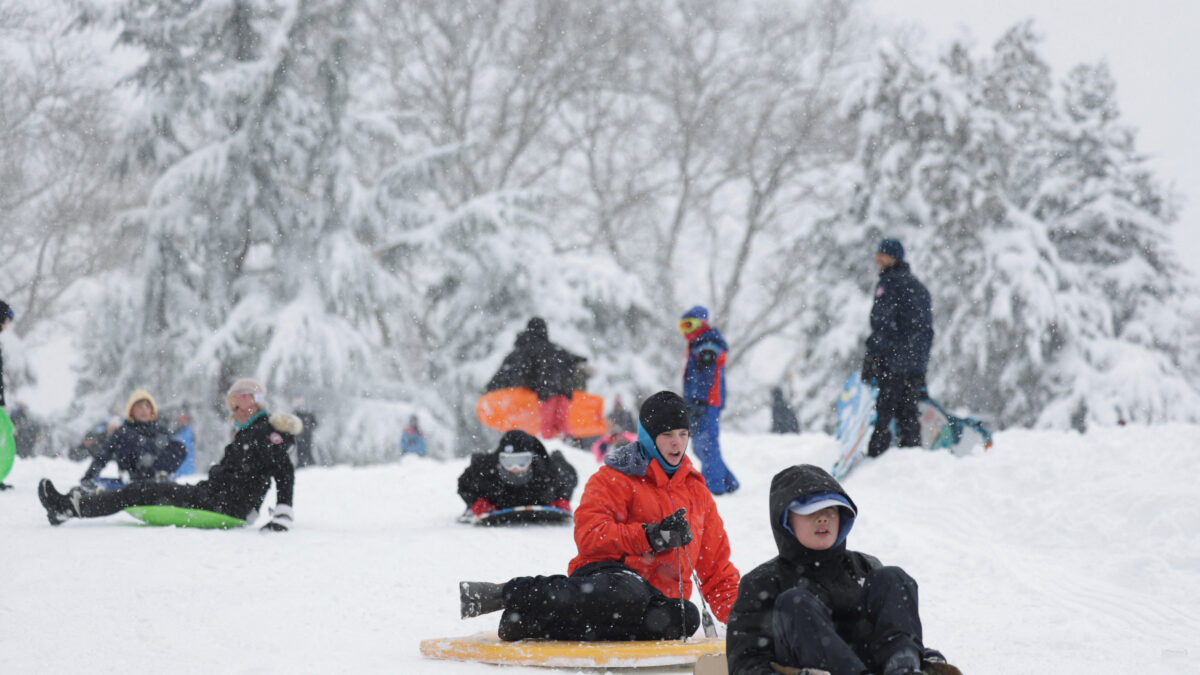 People sled in Central Park as snow falls during a winter storm in New York City, U.S., February 23, 2026. REUTERS/Jeenah Moon