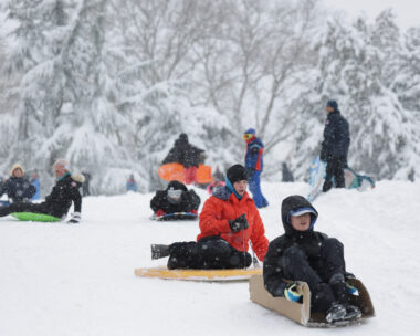 People sled in Central Park as snow falls during a winter storm in New York City, U.S., February 23, 2026. REUTERS/Jeenah Moon