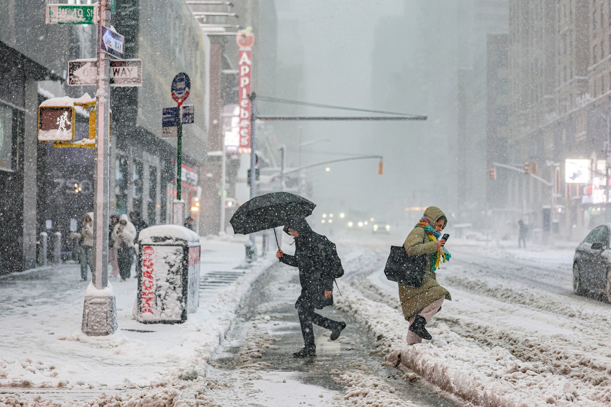Pedestrians walk on a street as snow falls during a winter storm in New York City, U.S., February 23, 2026. REUTERS