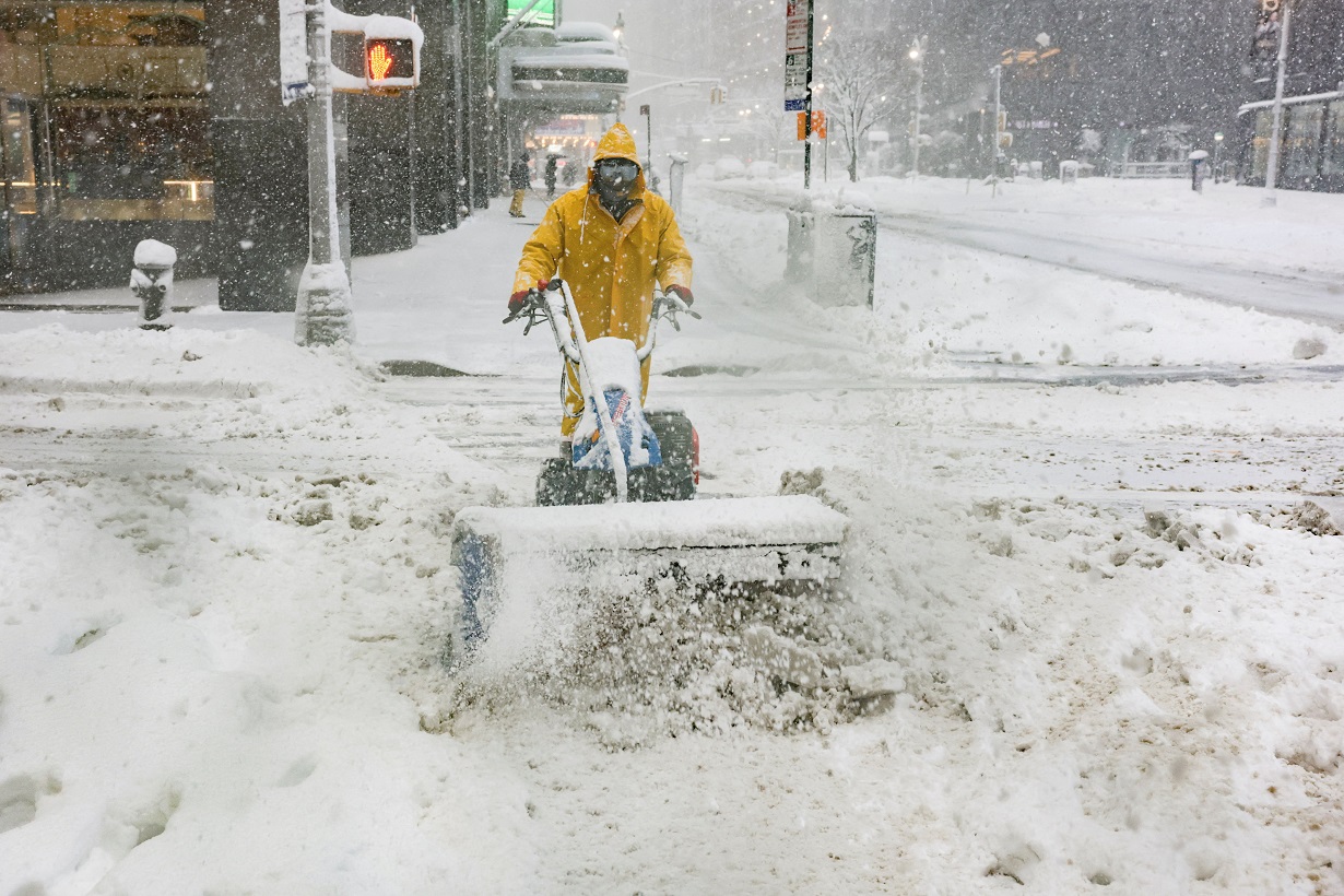 A worker clears snow on a street as snow falls during a winter storm in New York City, U.S., February 23, 2026. REUTERS