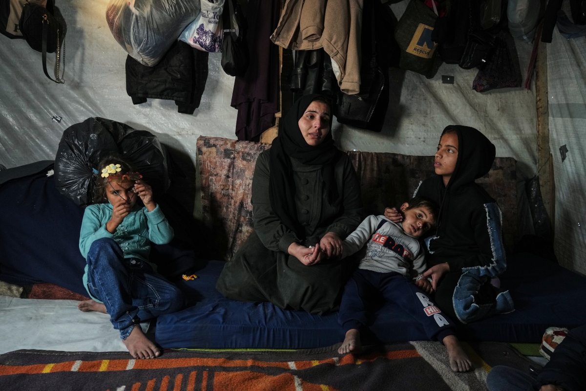 Rotana al-Regeb, who was allowed into Gaza from Egypt following the long-awaited reopening of the Rafah border crossing, reunites with her children in Khan Younis, southern Gaza Strip, Tuesday, Feb. 3, 2026. (AP Photo/Jehad Alshrafi)