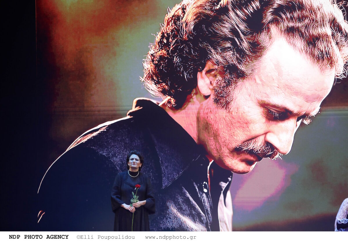 Η Άλκηστις Πρωτοψάλτη μπροστά από φωτογραφία του Νίκου Ξυλούρη