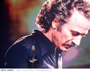 Η Άλκηστις Πρωτοψάλτη μπροστά από φωτογραφία του Νίκου Ξυλούρη