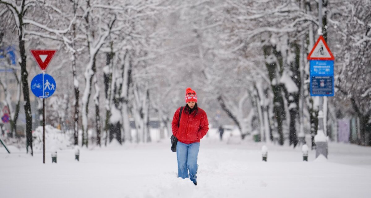 A woman trudges through snow after a blizzard in Bucharest, Romania, Wednesday, Feb. 18, 2026. (AP Photo/Vadim Ghirda)