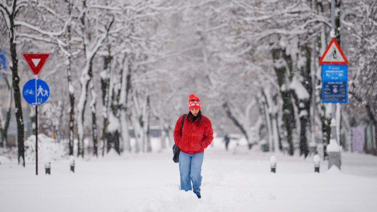 A woman trudges through snow after a blizzard in Bucharest, Romania, Wednesday, Feb. 18, 2026. (AP Photo/Vadim Ghirda)